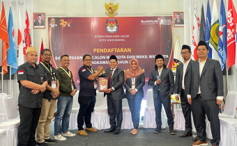 Ketua KPU Kota Singkawang menyerahkan cinderamata berupa maskot Pilkada kepada Ketua Bawaslu Kota Singkawang. ( Rabu 28/8 )